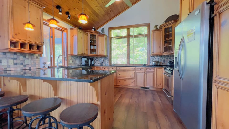 Fully equipped kitchen with stainless appliances and extra seating. 