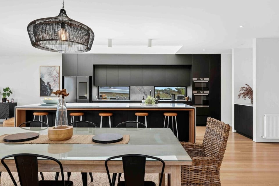 Modern kitchen with island seating and a bright dining area.