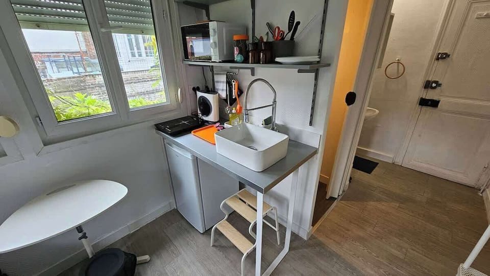 Kitchenette ouverte sur l'espace chambre, équipée avec plaque de cuisson, machine à café, micro-ondes et petit réfrigérateur.