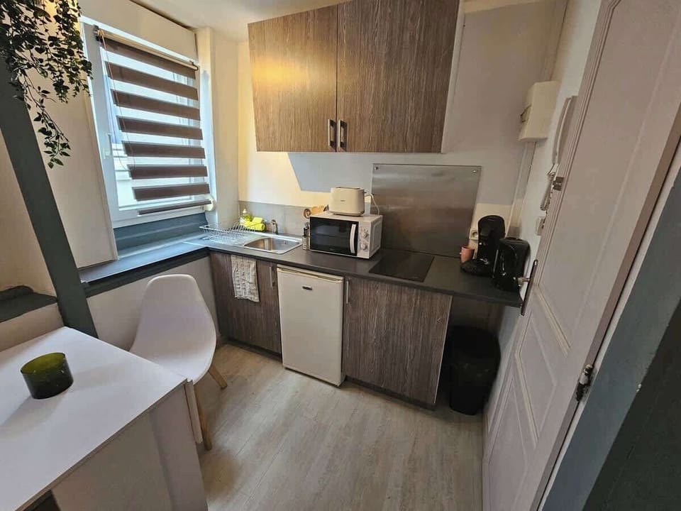 Cuisine équipée avec petit réfrigérateur, machine à café, bouilloire, plaques de cuisson et micro-ondes.
Coin salle-à-manger pour deux personnes.
La cuisine est ouverte sur l'espace salon.