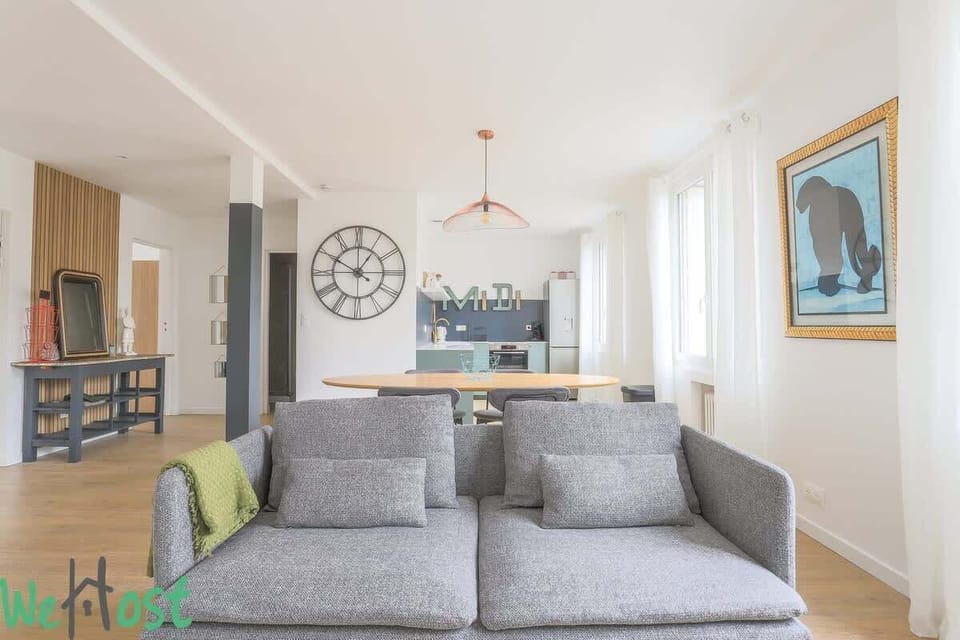 Salon avec TV HD et espace salle-à-manger, ouvert sur la cuisine.