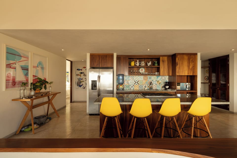 This modern kitchen features high-end appliances, stylish wood finishes, and an inviting bar area.
