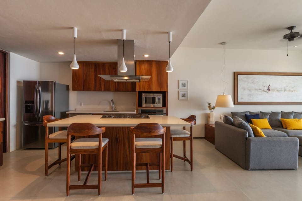 A beautifully designed open-concept space combining a gourmet kitchen, bar seating, and a cozy living room.