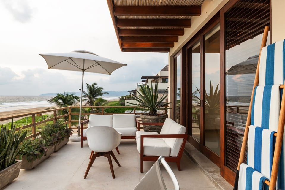 Unwind on this beautifully designed terrace, offering comfortable seating, lush greenery, and stunning beach views.