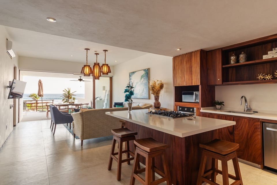 A stylish and functional space blending indoor and outdoor living, featuring a bar, cozy seating, and natural lighting.