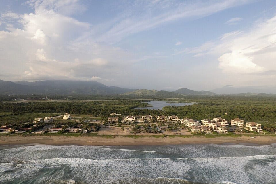 Nestled between lush greenery and the ocean, this serene community offers stunning views and
