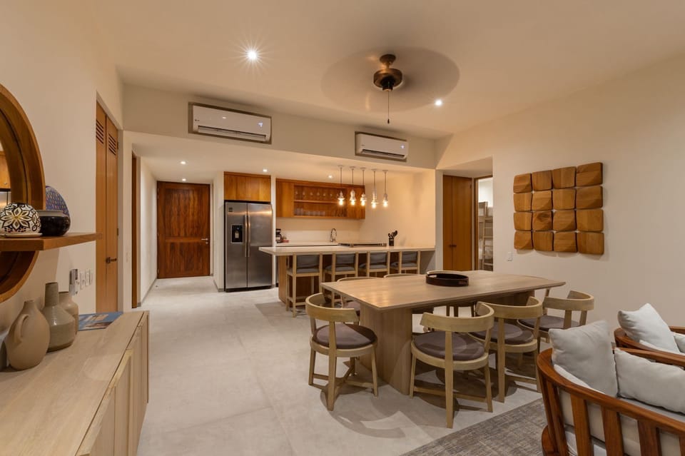 This open-concept space blends warm wood tones, contemporary lighting, and plush seating, creating a welcoming atmosphere for relaxation and dining.