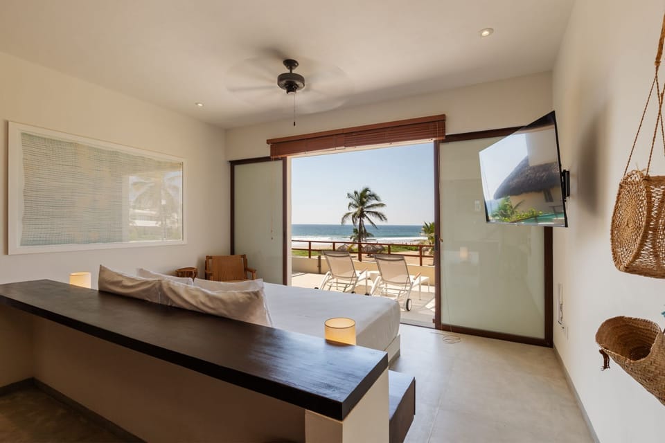 Wake up to the soothing sight and sound of the ocean in this elegantly designed bedroom with floor-to-ceiling views.