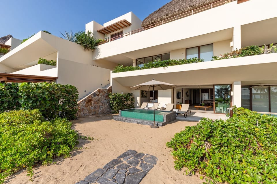 An exquisite beachfront villa featuring a private pool, tropical landscaping, and direct beach access for the ultimate retreat.
