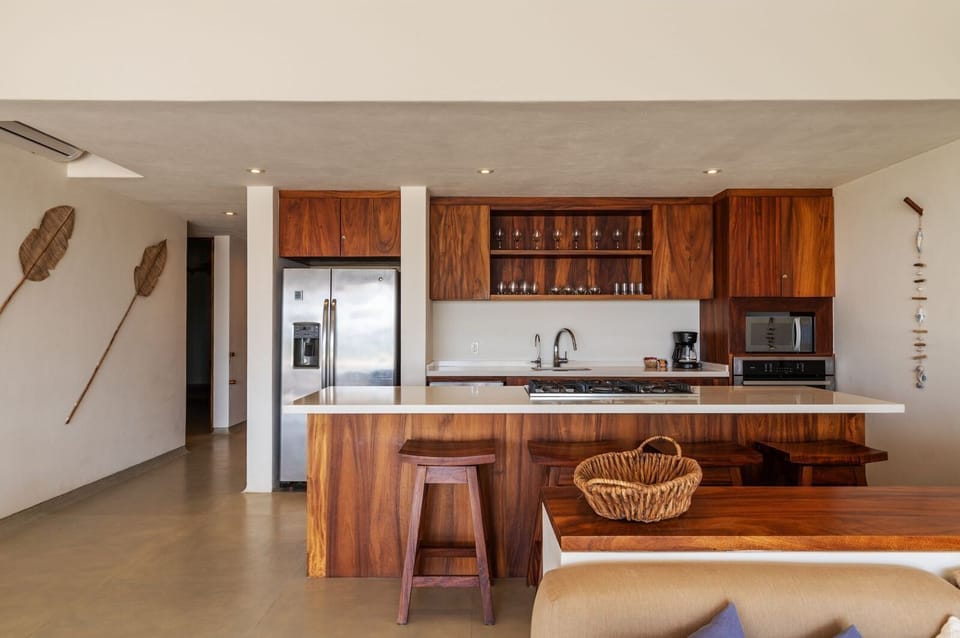 This chef's kitchen boasts high-end appliances, custom wood cabinetry, and a spacious island for dining and entertaining.