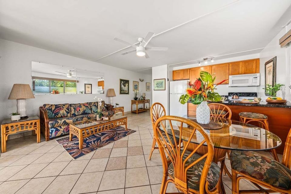 Open‑concept living room featuring seating, smart TV, and ceiling fan comfort.