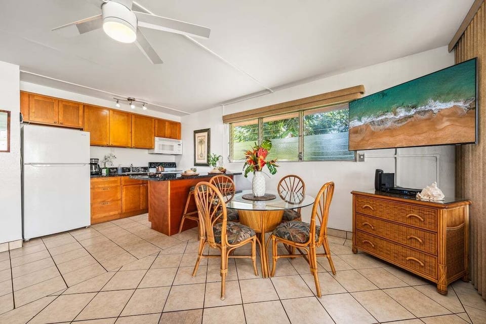 Dining area for four with bar seating and a fully equipped kitchen nearby.