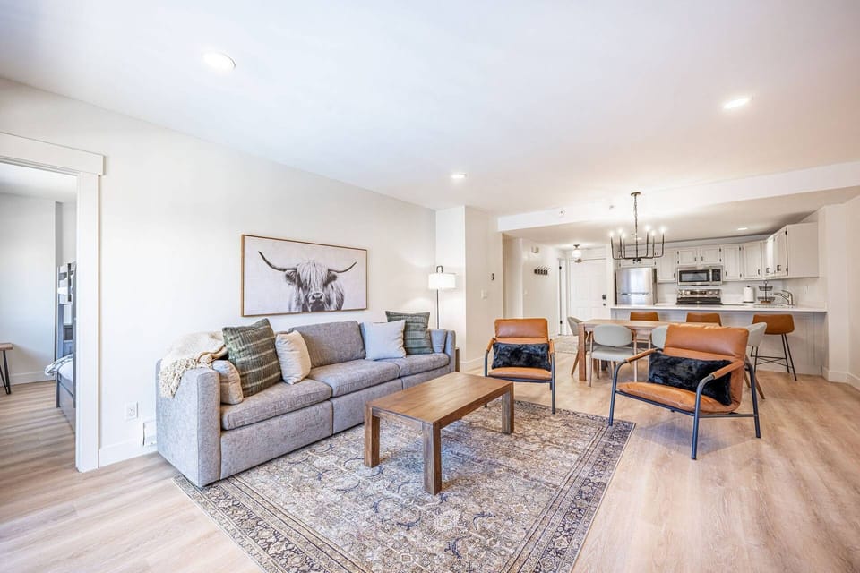 Living room with comfortable seating and TV, open to the kitchen and dining area. Home professionally cleaned prior to arrival.