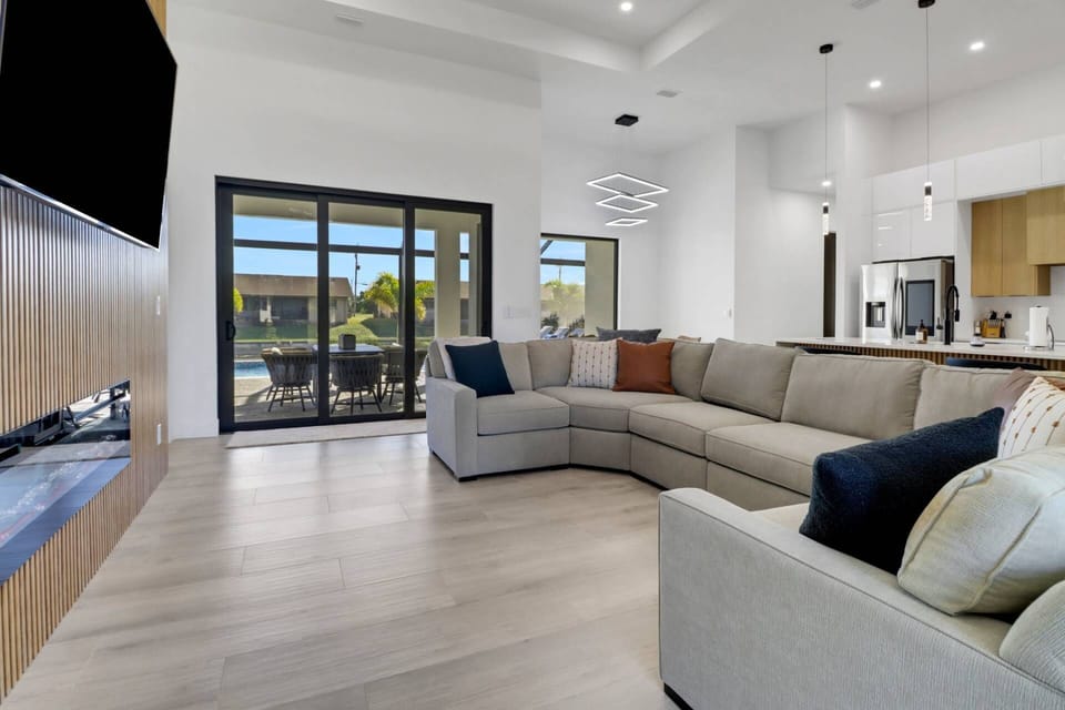 The open main living space includes living, dining and kitchen - all opening to the fully screened lanai and pool behind the home.