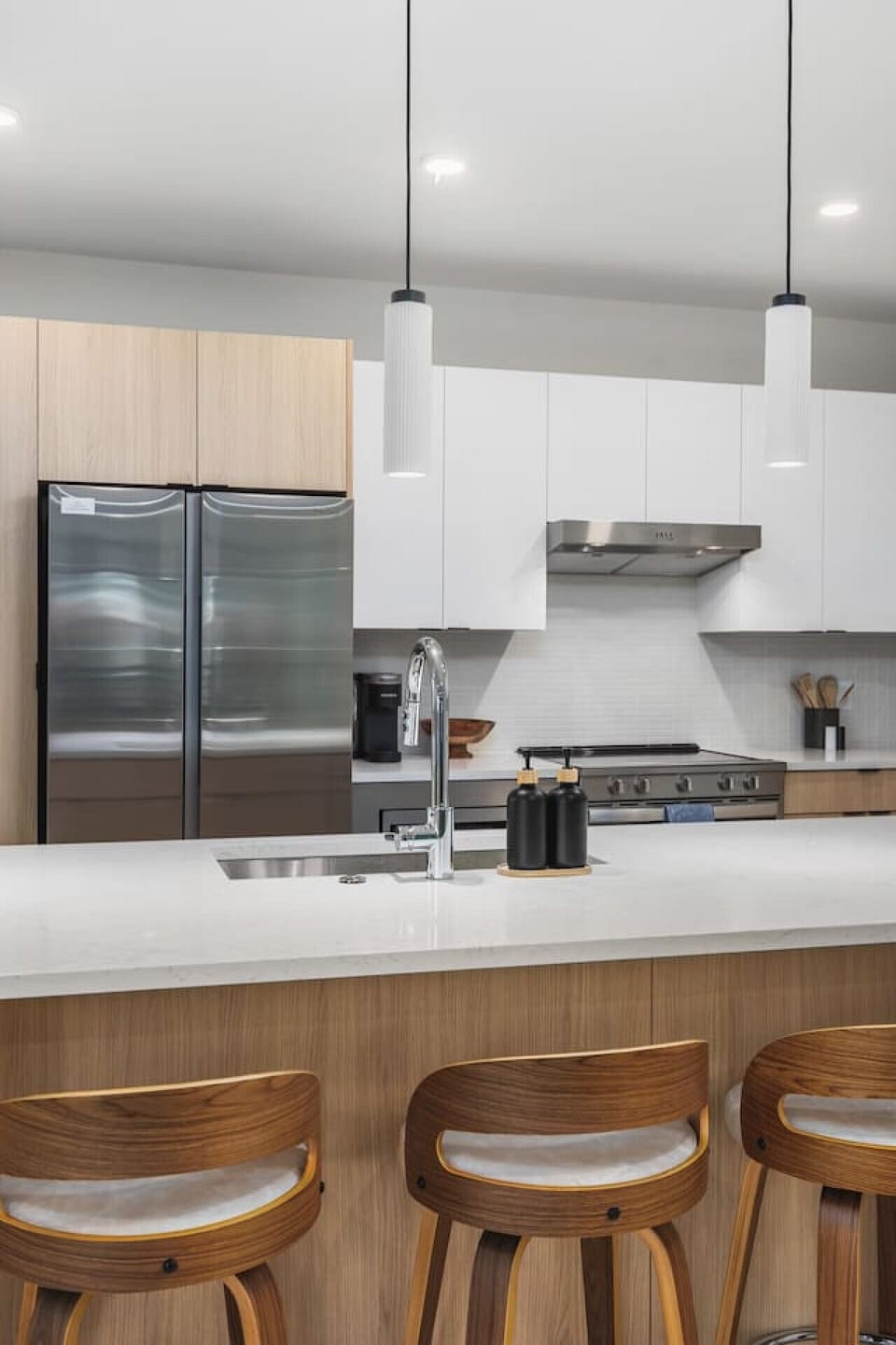 The kitchen is equipped with modern appliances, including a stainless still oven, large refrigerator, microwave, and energy efficient dishwasher.