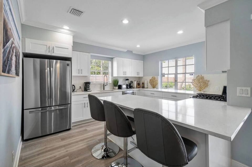 Modern Kitchen: Bright and airy space with sleek countertops and inviting seating for culinary adventures!