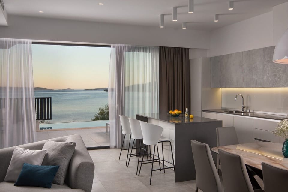 As you step inside, you are greeted by a seamless open-plan living, dining, and fully equipped kitchen area and a wonderful view of the sea
