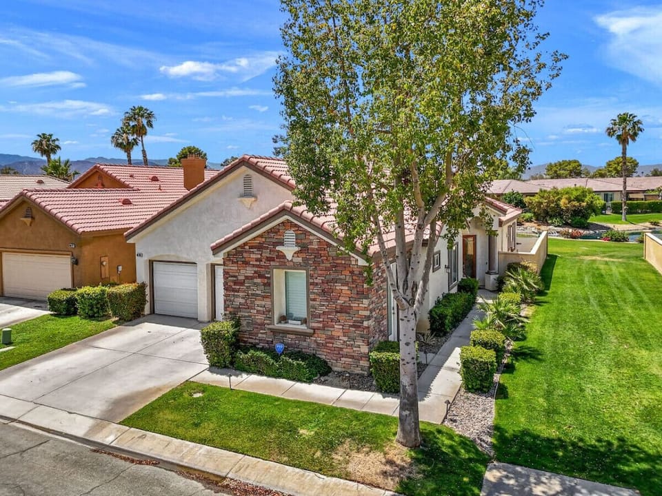Charming exterior view showcasing tidy landscaping & welcoming curb appeal.