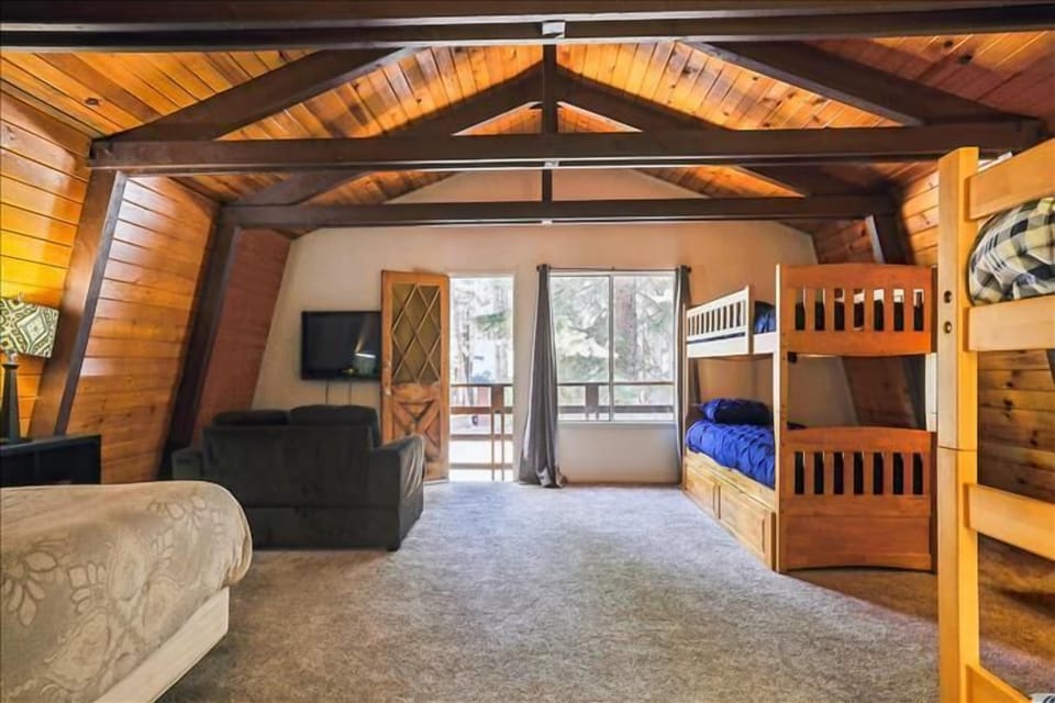 Loft area with bunk beds and TV, offering plenty of space for entertainment and relaxation.