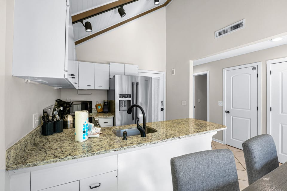 Modern kitchen with granite countertops, stainless steel appliances, and vaulted ceilings