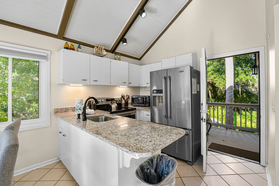 Bright, open kitchen with granite countertops, stainless steel appliances, and vaulted ceilings