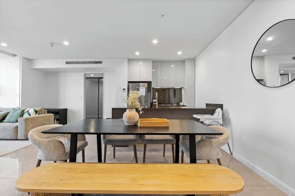Modern dining table with a wooden bench and luxe fabric chairs—perfect for shared meals. A high chair is also available for little ones.