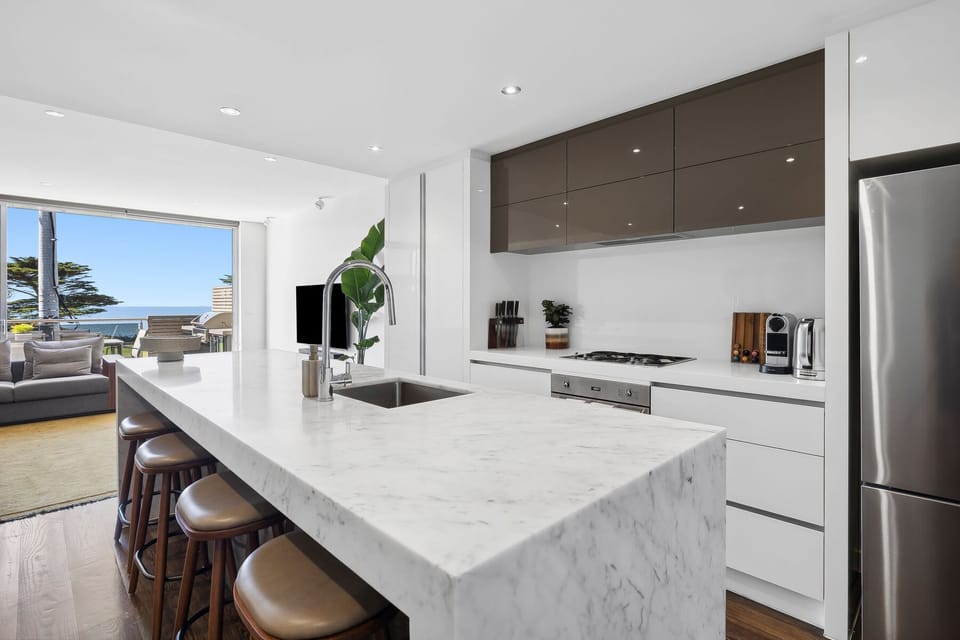 Featuring marble countertops, Smeg appliances, and an abundance of cabinet space, this kitchen makes cooking a pleasure
