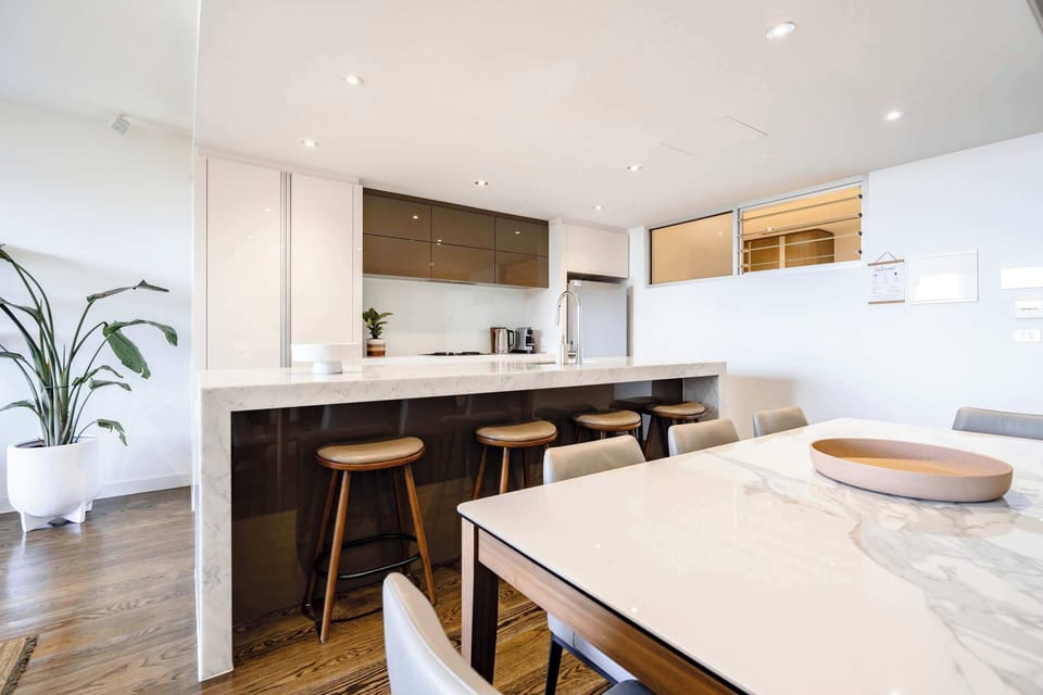 The kitchen is fully equipped and stylish, with stools at the island bench for casual meals and an 8 Seater Dining Table