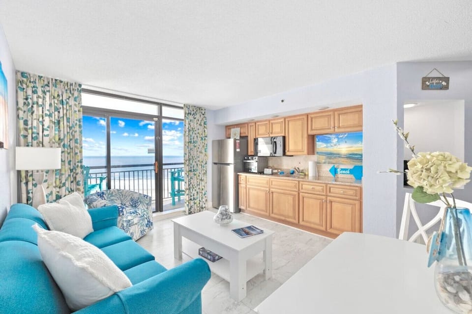 Bright oceanfront living room in Tower B at Beach Cove Resort with breathtaking Atlantic views, natural light, and a relaxing coastal setting for your Myrtle Beach getaway.