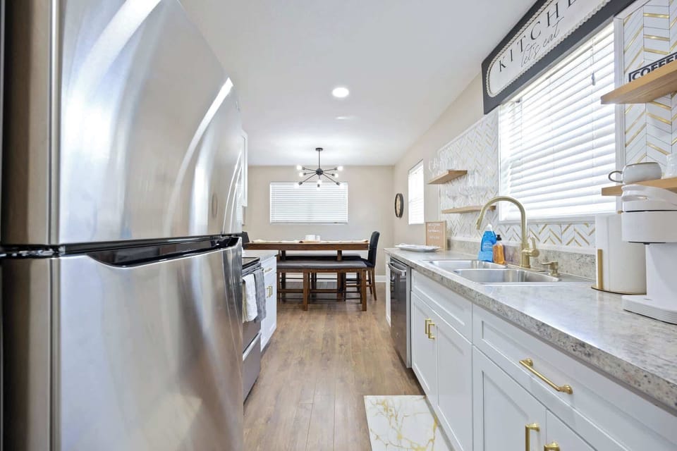 Modern kitchen with stainless steel appliances and a dining area with natural light