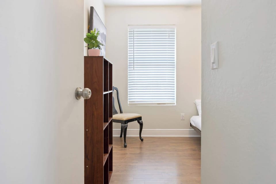 Natural light fills this simple room with a wooden floor and classic chair.