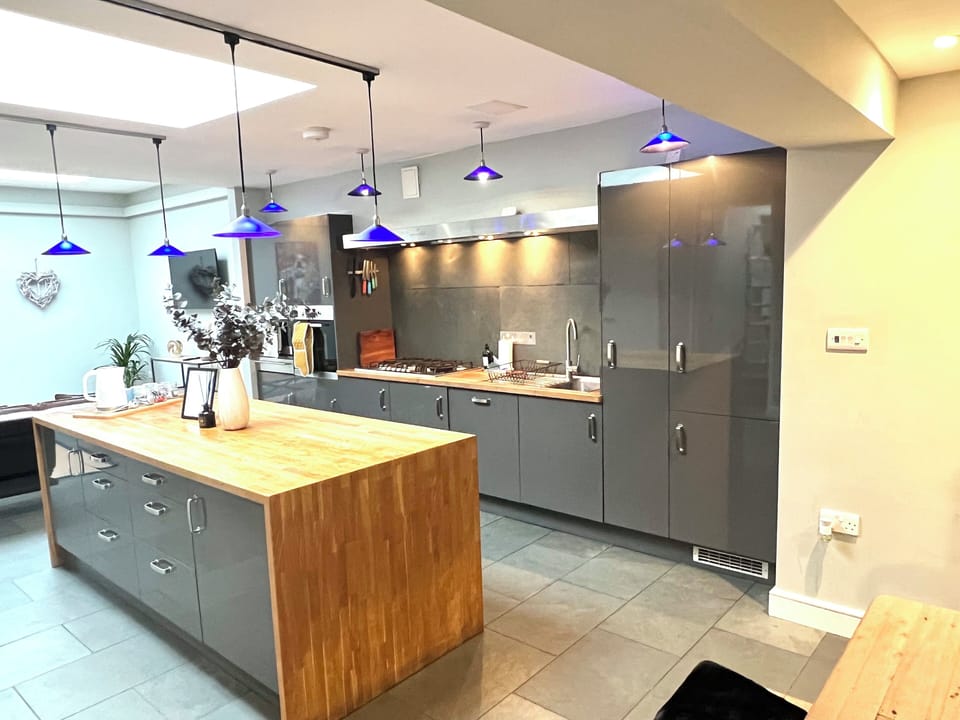 Modern Kitchen: Sleek surfaces, vibrant lighting, and ample space for culinary adventures await!
