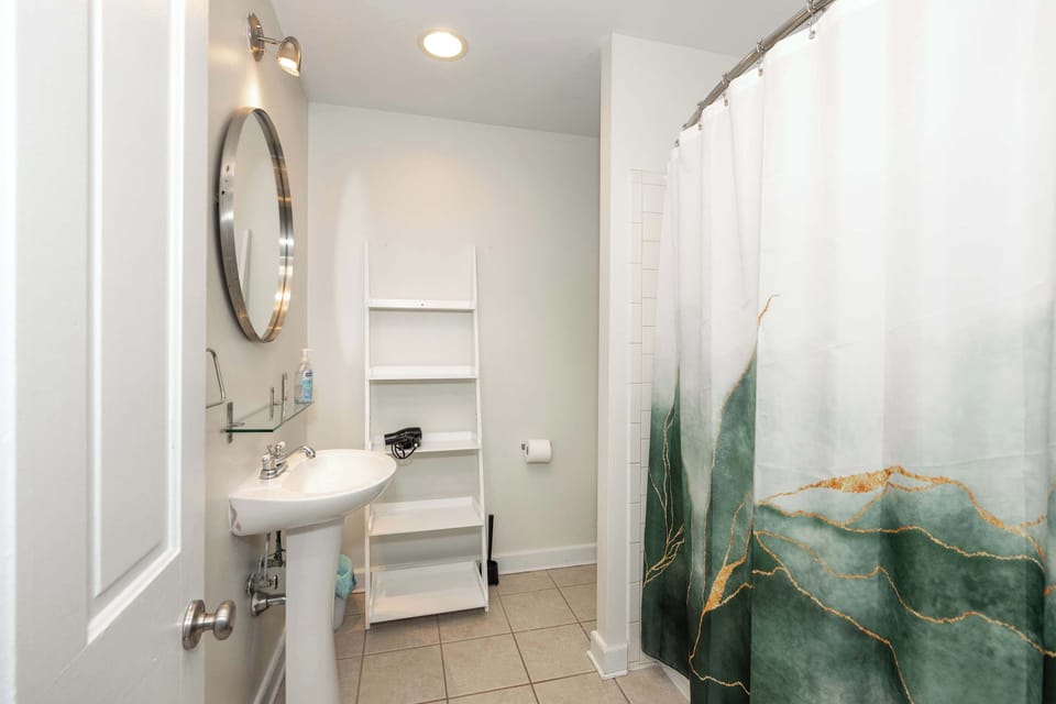 The upper-level full bath includes a pedestal sink & shower/tub combo