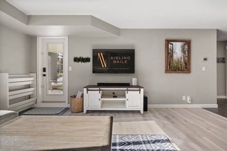 Living room with a Smart TV with cable, a sound system, board games, cozy seating options, and walkout access to the ground-floor patio. From there, you`re just steps from the outdoor pool, hot tub, fitness centre & minute from Lake Windermere.