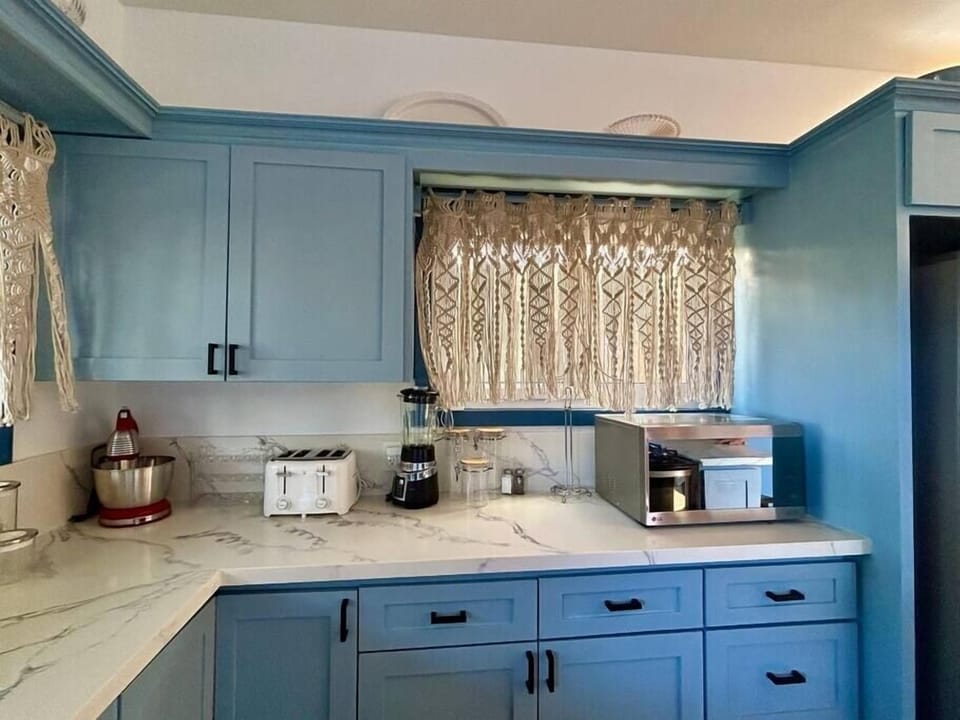 Kitchen has many cabinets, toaster, blender, coffee maker, mixer
