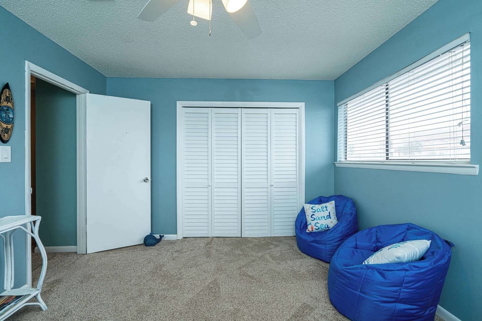 The 1st of 2 upper-level bedrooms is ideal for kids, featuring twin beds & a Smart TV
