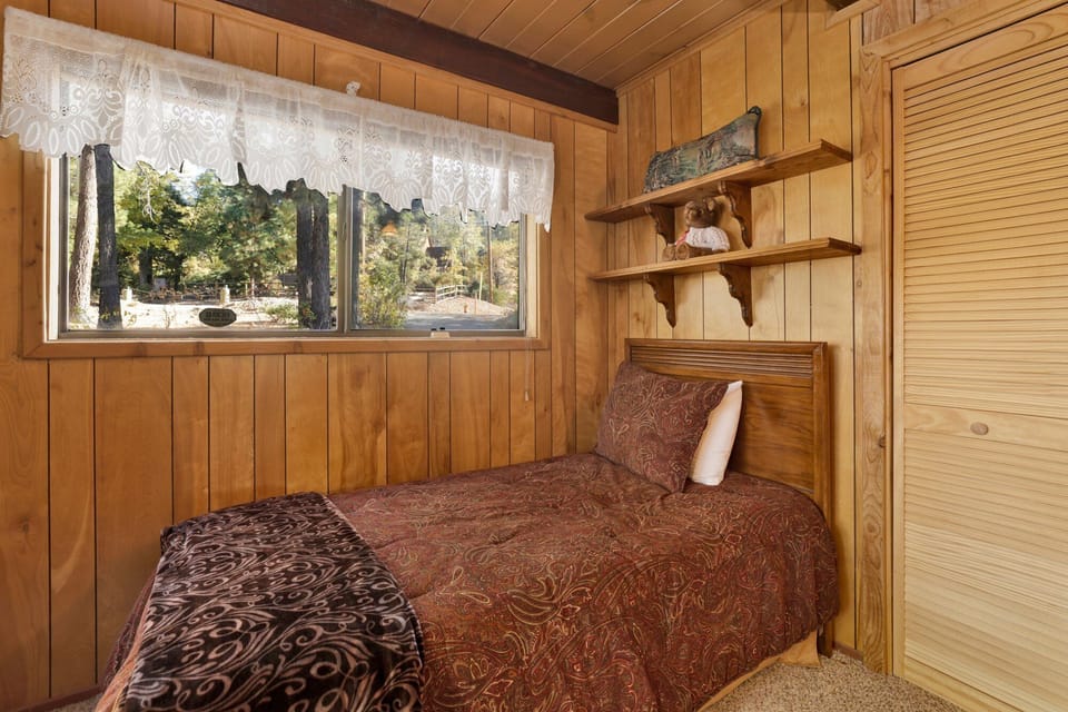 Peaceful cabin bedroom with plush bedding, and beautiful views—ideal for restful nights, cozy mornings, and a relaxing mountain escape.