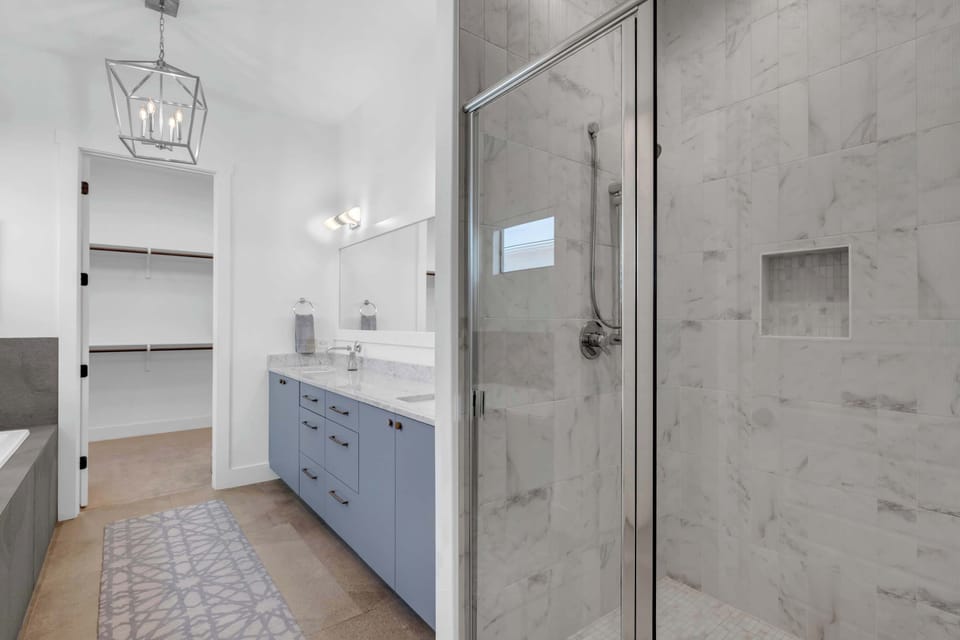Primary en-suite bathroom has a tiled glass-door shower and a double vanity!