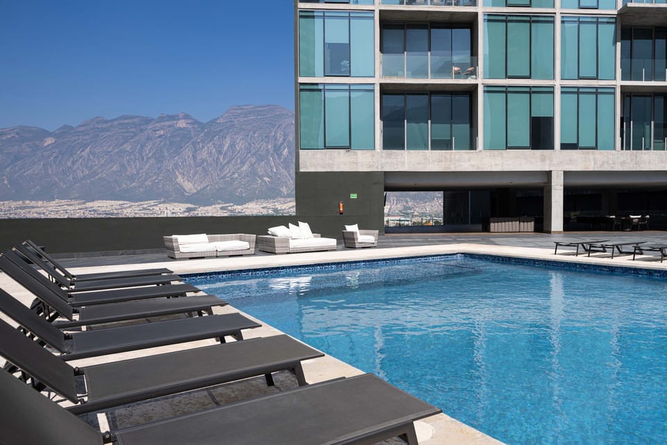 A modern outdoor pool with loungers and sweeping panoramic views (Pool towels not provided).