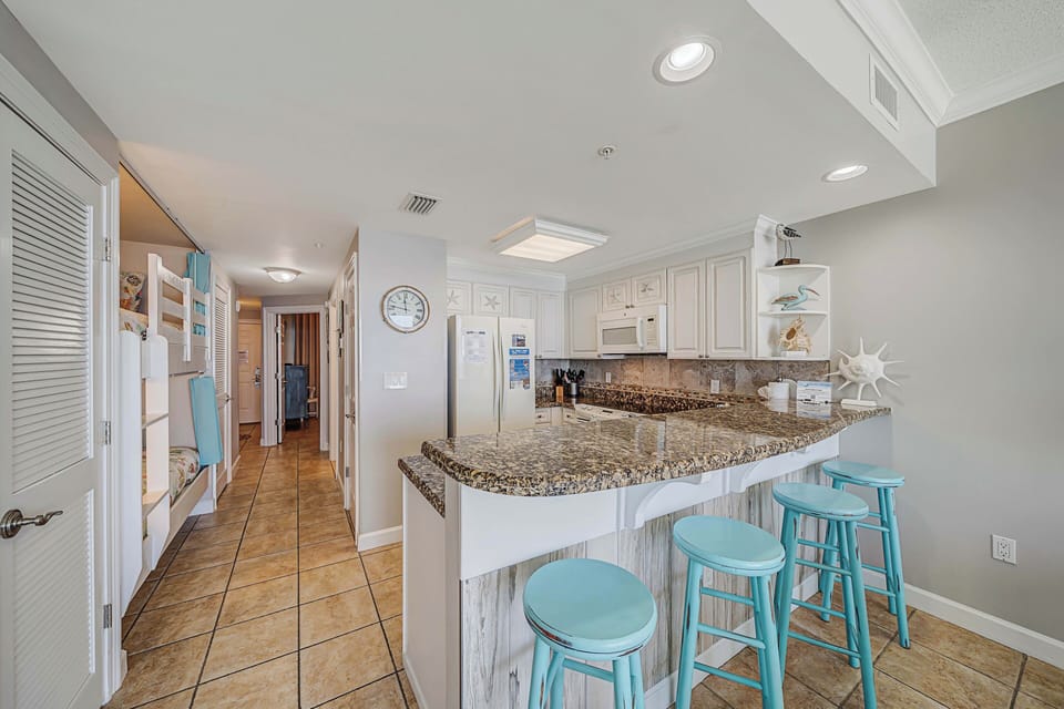 There is a dining table, perfect for enjoying a meal or playing a game, as well as additional breakfast bar seating.