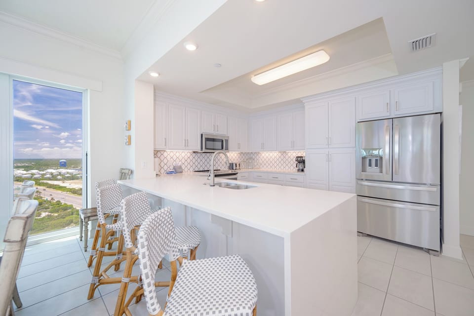 Bright kitchen welcomes you to gather around the breakfast bar and prepare fresh meals with ease