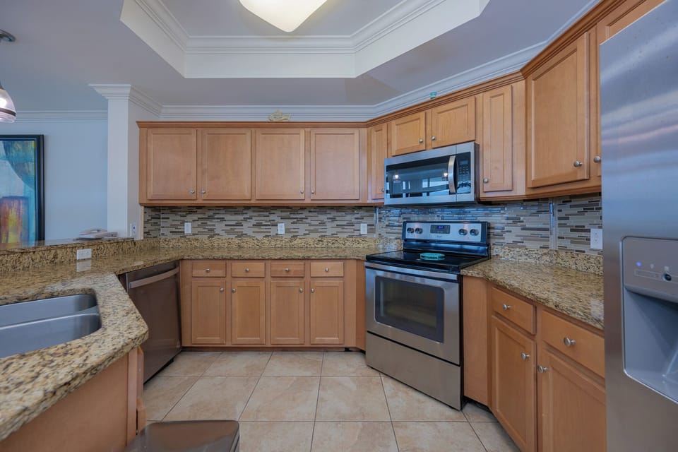 Prepare meals in this kitchen with elegant cabinetry, stainless appliances, and stylish backsplash