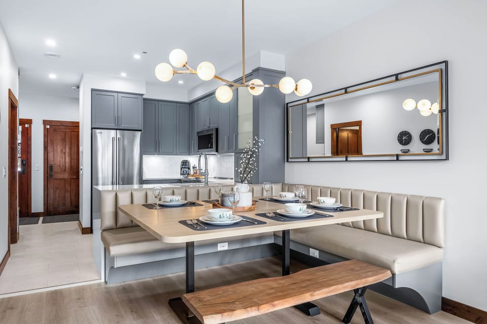A beautiful pendant light above the dining table illuminates the space, tying together the room's modern and functional design.