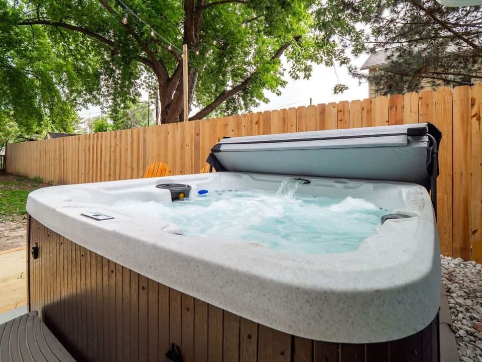 - Private outdoor hot tub with bubbling jets and relaxing vibes   - Surrounded by privacy fence and shaded by tall trees   - Perfect backyard spa for evening soaks under string lights  