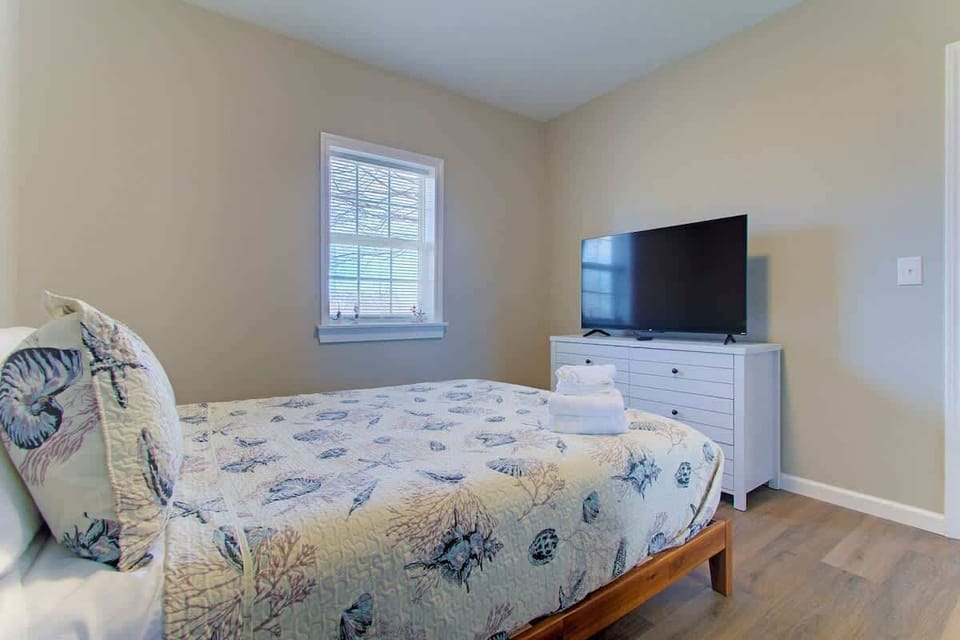 Unwind in bed while enjoying the TV across the room for easy evening entertainment