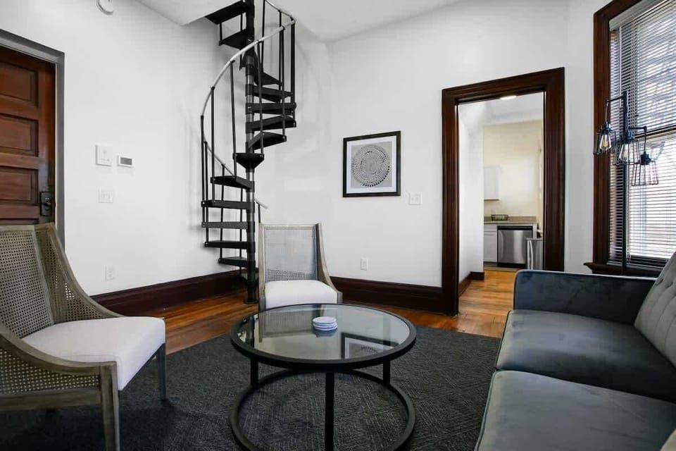 Inviting living area w/ spiral staircase, comfy seating & round coffee table