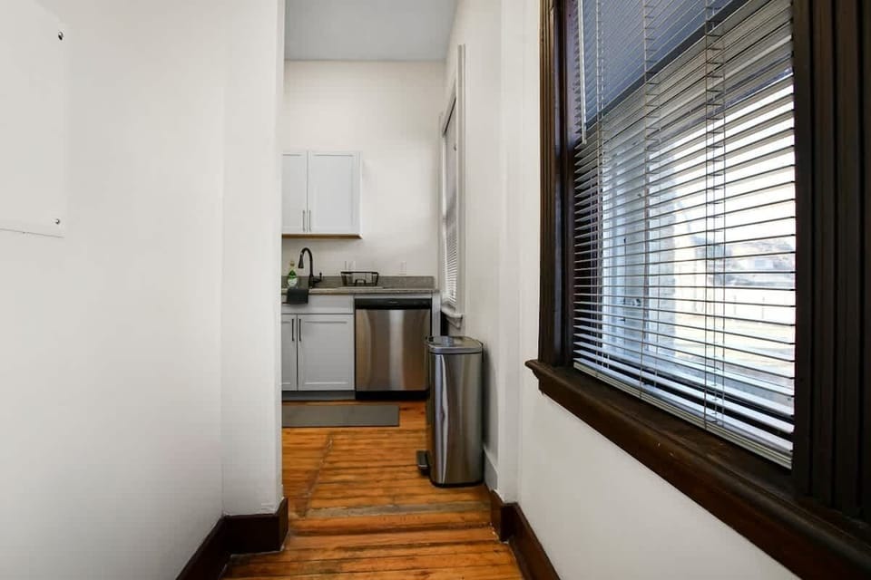 Hallway w/ large windows leading to the kitchen, filling the space w/ natural light
