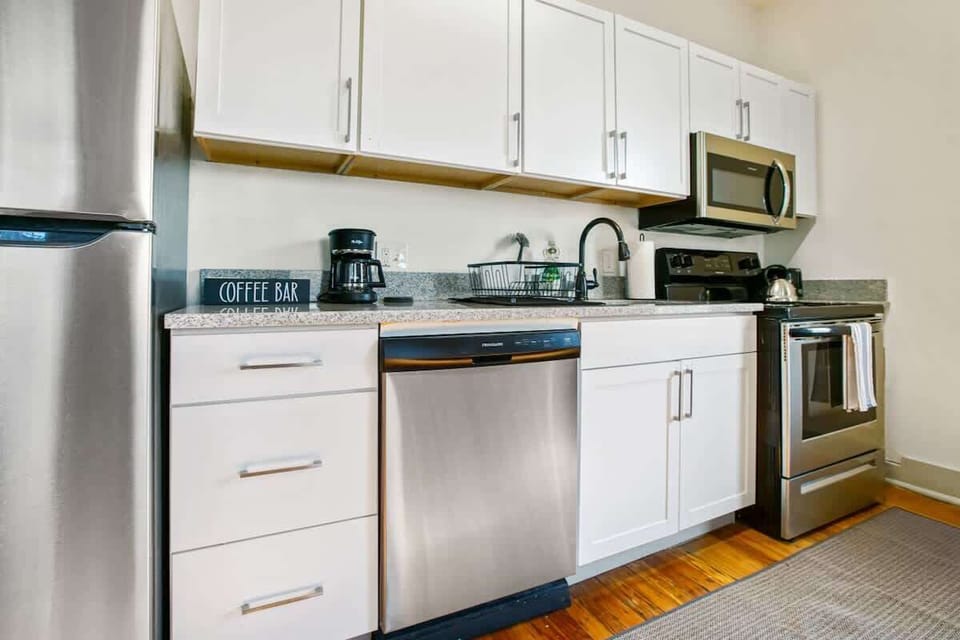 Modern kitchen counter w/ coffee maker, dishwasher & sleek stainless appliances for easy stays