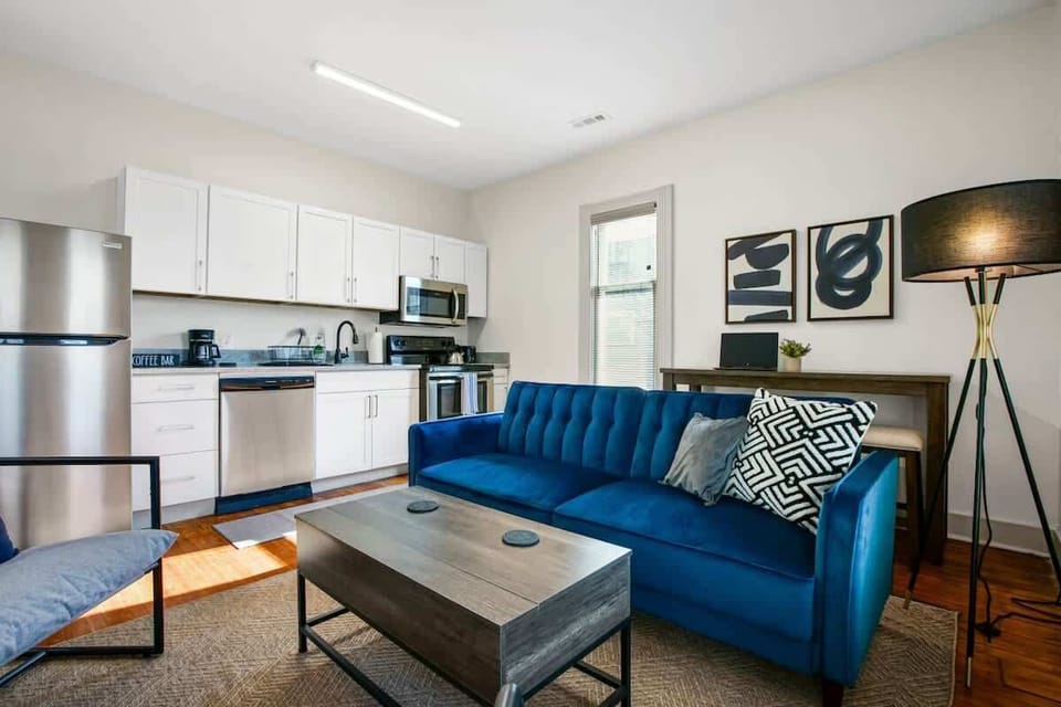 Stylish living area w/ blue sofa, coffee table & kitchen just steps away for laid-back evenings