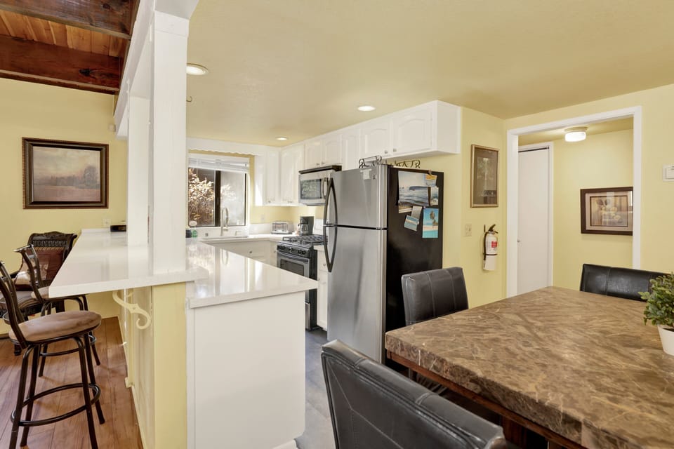 Fully equipped cabin kitchen with ample cabinetry, stove, fridge, microwave, and coffee maker—perfect for cooking meals, morning coffee, and feeling right at home on your stay.